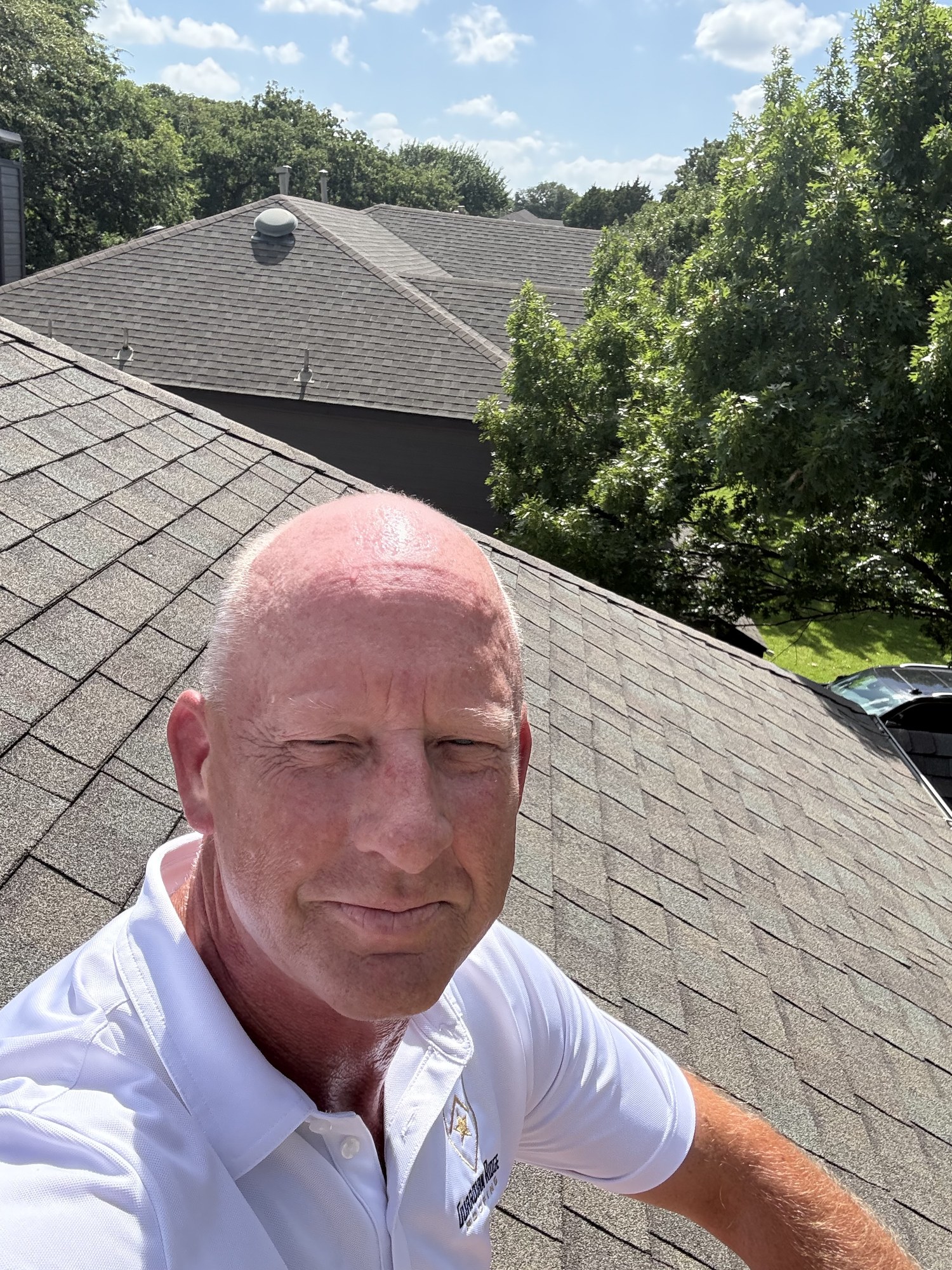Guardian Ridge Roofing team member inspecting shingles on a residential roof